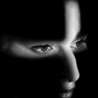 Marcel Mütze
<br><br>
<p class="has-text-align-right has-large-font-size">„Plus“</p>
<br>
Wenn wir an Schattenspiele denken, dann werden viele Menschen mit ihren Gedanken erst einmal in ihre Kindheit zurückversetzt.
<br>Erinnerungen kommen hoch, von Hasen, Vögeln, Hunden und anderen Tieren, die mit den Händen als Schatten an die Wand geworfen wurden.
<br>
<br>Auch die Fotografie ist ein Spiel mit Licht und Schatten.
<br>Auf dem Foto ist das Gesicht des Models nur teilweise zu sehen, doch woher kommt das Licht? <br>Wie wird es geformt? Woran denkt das Model? Welche Gedanken löst die Betrachtung in Ihnen aus? <br>Hier kann der Fantasie freien Lauf gelassen werden.